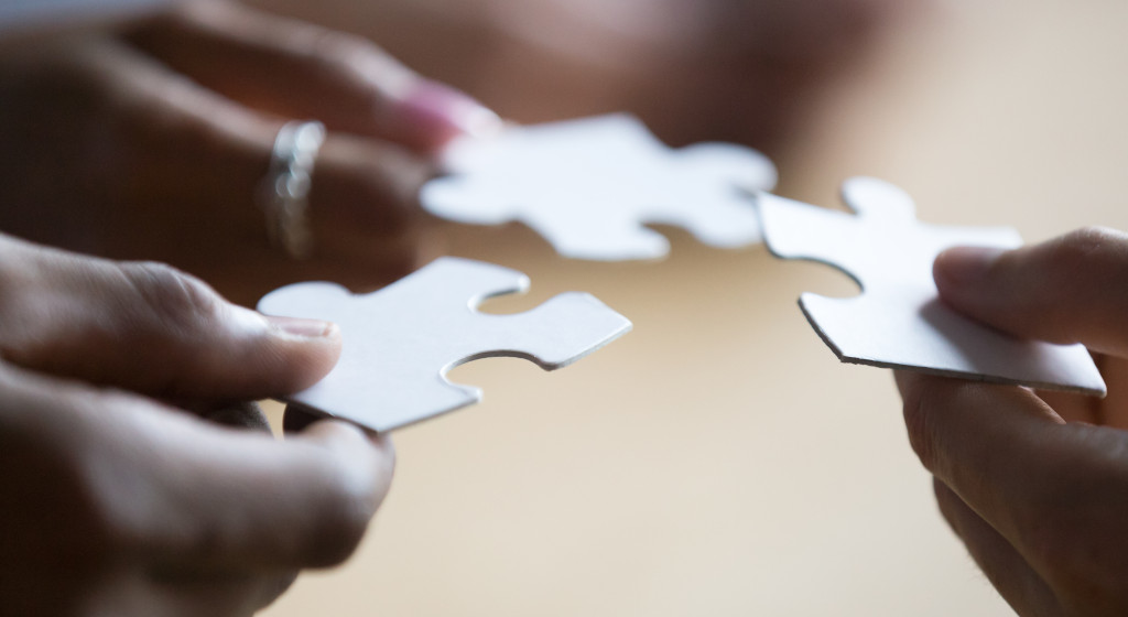 manos con piezas de puzzle
